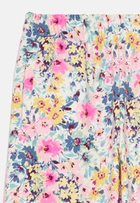 Calças de tecido suave com um vibrante padrão floral em rosa, amarelo, azul e verde, apresentando uma cintura elástica e bolsos laterais.