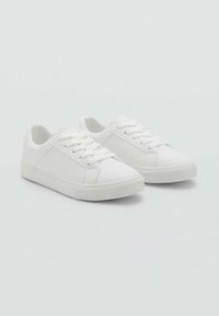 Sneakers bianchi in tela con design a taglio basso, punta rotonda e suola piatta in gomma. Laccio frontale con texture liscia e stile minimalista.