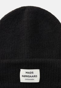 Beanie nero lavorato a maglia con una finitura morbida e testurizzata. Presenta un risvolto e un'etichetta bianca con la scritta "MADS NØRGAARD COPENHAGEN."