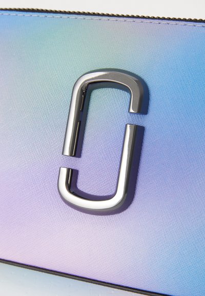 Textured, gradient purse displaying shades of blue and purple, featuring a prominent silver hardware accent in the shape of a stylized 'C'.