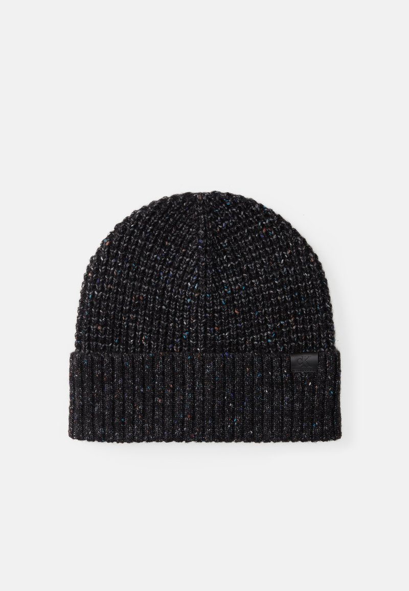Gebreide zwarte beanie met een geribbelde structuur, voorzien van subtiele multikleurige stippen en een klein zwart logo-label op de omslag.