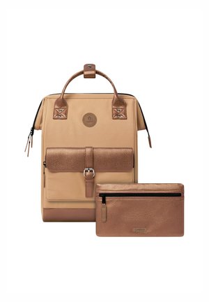 Zaino beige e bronzo con tasca frontale con fibbia e pochette coordinata con cerniera bronzo posizionata davanti. Entrambi gli articoli presentano dettagli in pelle testurizzata.