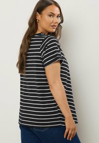 Zwart-wit gestreepte T-shirt met korte mouwen, een relaxed fit en een ronde zoom. Het stof lijkt zacht en lichtgewicht te zijn.