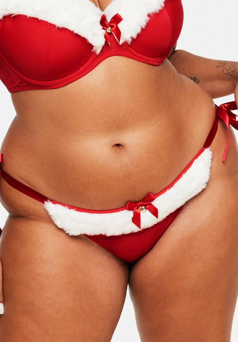Ensemble de lingerie rouge avec des bordures en fausse fourrure blanche. Le soutien-gorge présente un détail de nœud et de cloche, tandis que le string assorti a des accents de côté noués.