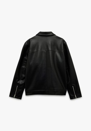 Mustan nahkajakun, jossa on kaulus, vetoketjut hihoissa ja sileä pinta. Takana saumat ja klassinen leikkaus. Etunäkymää ei ole näkyvissä.