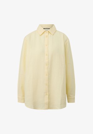 Koszula z długim rękawem w bladożółtym kolorze, wykonana z teksturowanej bawełny, z zapięciem na guziki z przodu i klasycznym spiczastym kołnierzem.