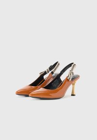 Escarpins slingback en cuir verni orange avec un bout pointu, un talon doré accentué, et des brides noires avec des détails de logo.