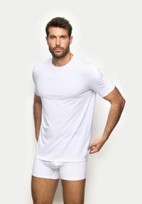 T-shirt bianco a maniche corte abbinato a boxer bianchi. Tessuto morbido; design aderente che mette in risalto la forma del corpo superiore. Aspetto semplice e pulito.