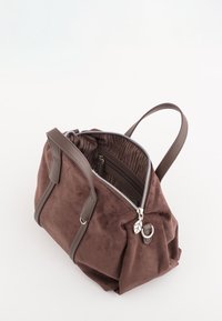 Hnědá surová kůže kabelka s koženými uchy, částečně otevřený zip ukazuje pruhovanou látkovou podšívku a zipovou vnitřní kapsu.