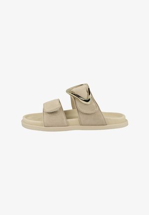 Beige slip-on sandal with two adjustable suede straps, one featuring a large gold triangular buckle detail.