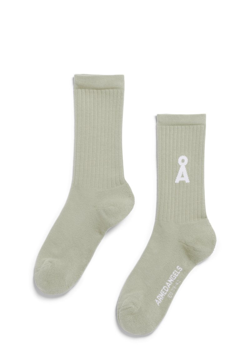 Chaussettes côtelées vert clair en matériau doux, avec un logo blanc sur le côté et une texture lisse tout au long.