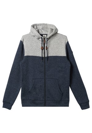 Pánská mikina s kapucí, která má šedou horní část a tmavě námořnickou spodní část, zapínání na zip, přední kapsy a stahovací šňůrky.
