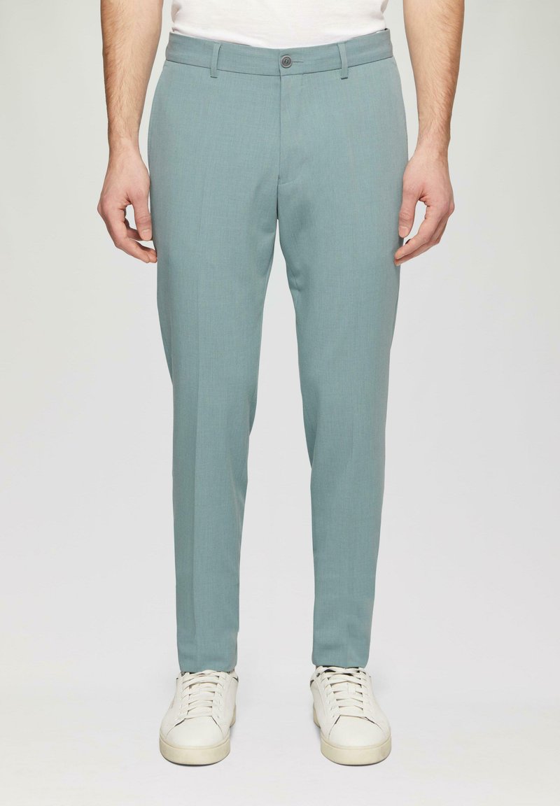 Himmelblaues, tailliertes Hosen aus glattem Stoff, mit Knopfverschluss und Seitentaschen, kombiniert mit weißen Sneakers.