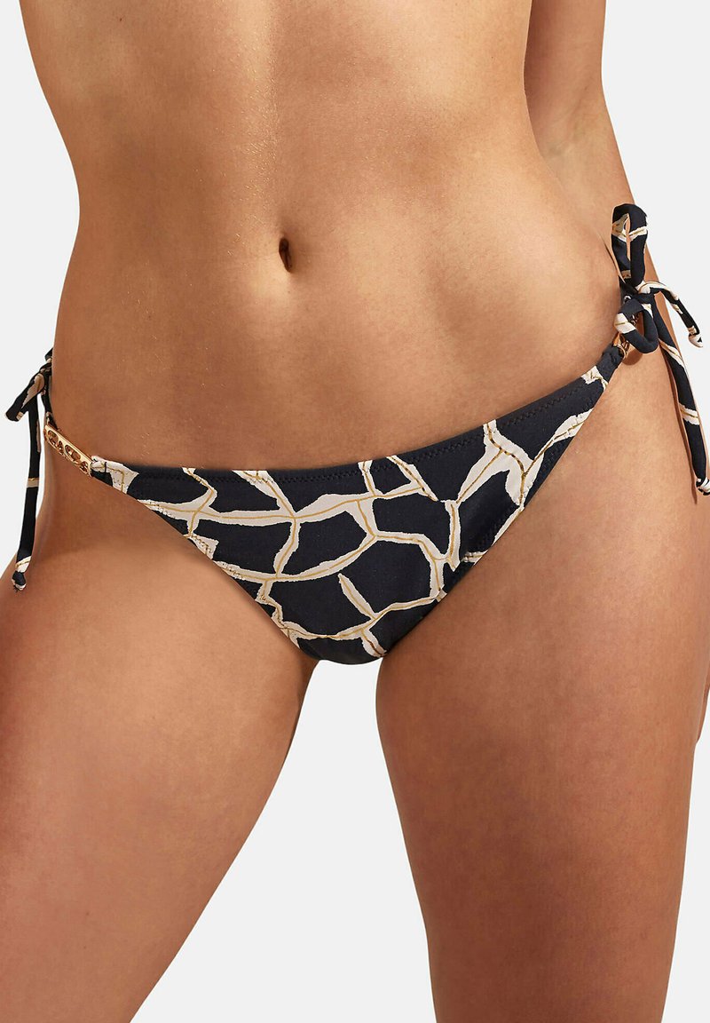 Bas de bikini navy avec imprimé girafe doré. Présente des fermetures à nouer sur les côtés et des éléments décoratifs. Tissu lisse avec une finition mate.