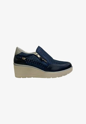 Scarpe con zeppa in pelle blu navy con motivo traforato, accentate da una cerniera argento e una suola in beige chiaro.