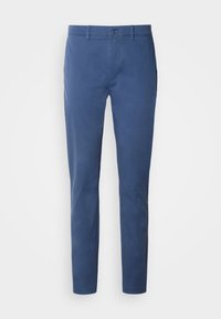Blå chinos laget av bomull med en glatt tekstur. Har knappelukking, to frontlommer og avsmalnende ben.
