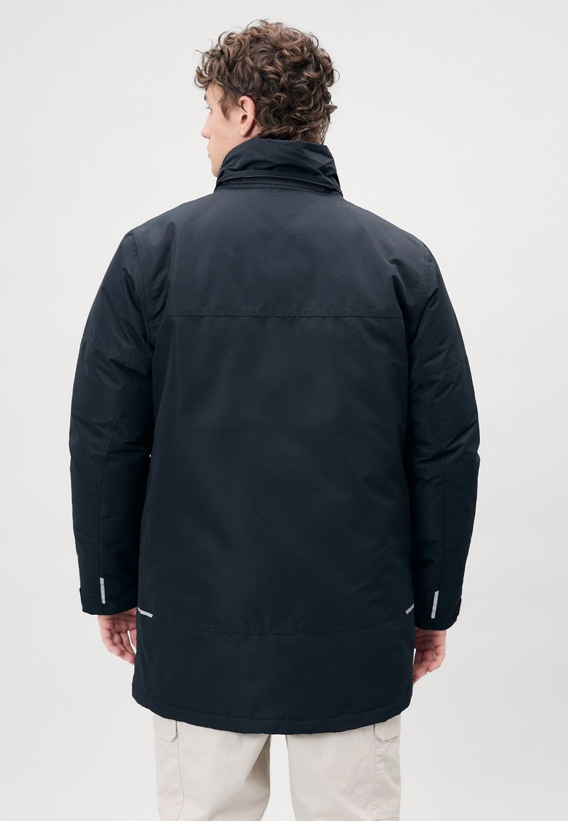 Zwarte gewatteerde jas met een hoge kraag, lange mouwen en reflecterende accenten. Heeft een rechte snit en een gladde stofstructuur.