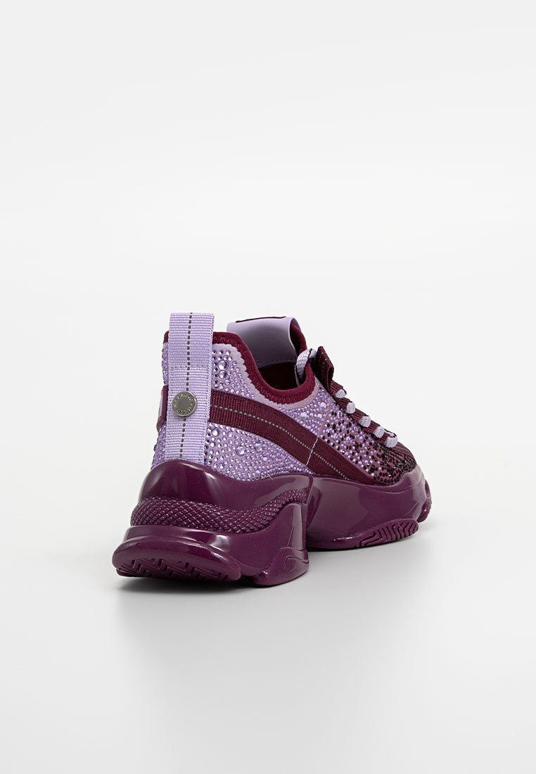 Zapatillas moradas con parte superior de malla texturizada, suela brillante y acentos decorativos. Los detalles reflectantes y una pestaña de tira en el talón mejoran el diseño.
