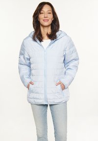 Šviesiai mėlyna pūkinė striukė su užtrauktuku priekyje, reguliuojamu gobtuvu ir šoninėmis kišenėmis. Pasižymi horizontaliai quilted tekstūra ir lygiu audiniu.
