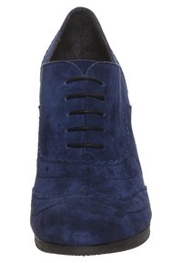 Marinblå mockaskor med sju öglor, dekorativ broguedetalj och slät yta. Rundad tå med låg, platt sula.