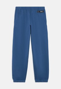 Μπλε φόρμες κατασκευασμένες από μαλακό ύφασμα, με ελαστική μέση, πλαϊνές τσέπες και ελαστικές μανσέτες στους αστραγάλους. Μπαλώμα με λογότυπο στο πίσω μέρος.