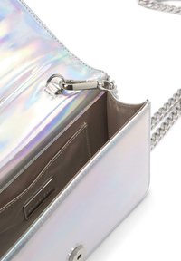 Bolso cruzado iridiscente con acabado metálico, correa de cadena y cierre con cremallera que revela un interior beige con un bolsillo. Acentos de hardware plateado.