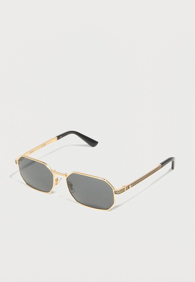 Γυαλιά ηλίου με χρυσή τετράγωνη κορνίζα και σκουρόχρωνους γκρι οκταγωνικούς φακούς, με μαύρες άκρες στα μπράτσα και διακοσμητικό σχέδιο στα μπράτσα.