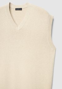 Pull sans manches en maille beige avec un col en V. Présente des bords côtelés et une texture douce. Étiquette indiquant "CALLIOPE." Conception légère et flexible.