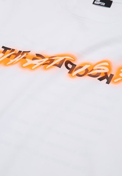 Hvid bomulds-T-shirt med fed sort og orange tekst med en gradient-effekt. Rund hals design og blød stoftekstur.
