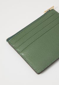 Green leather wallet featuring a textured surface, four card slots, a zippered compartment, and gold-tone hardware accents.
