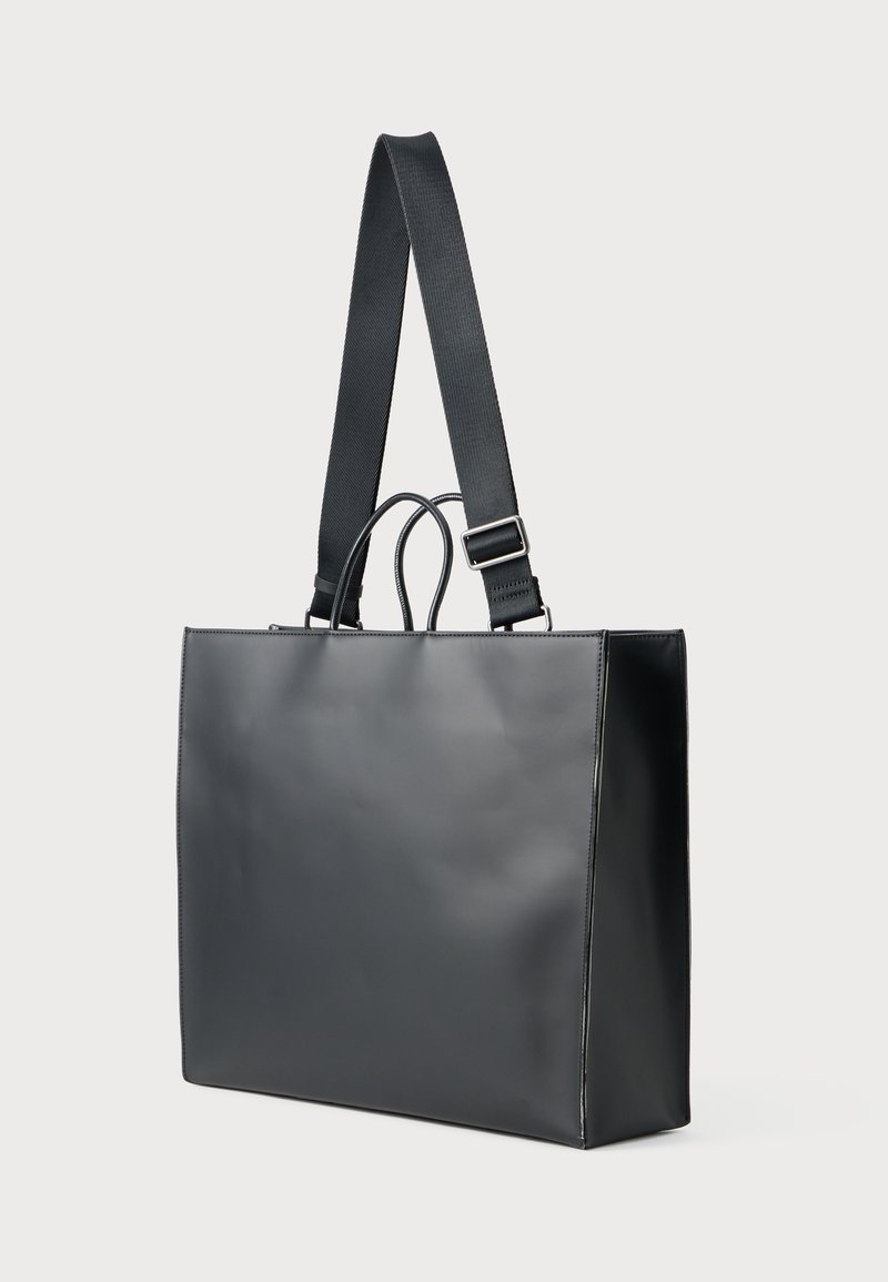 Borsa tote nera con una finitura liscia e elegante, dotata di una tracolla intrecciata e manici doppi per opzioni di trasporto versatili.