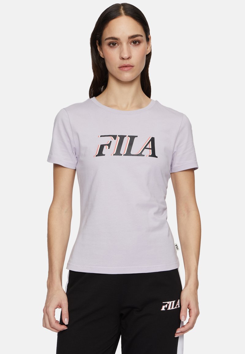 Camiseta de algodón de manga corta en color lavanda, con un destacado logotipo "FILA" en negro y rosa en el pecho. Diseño clásico de cuello redondo.