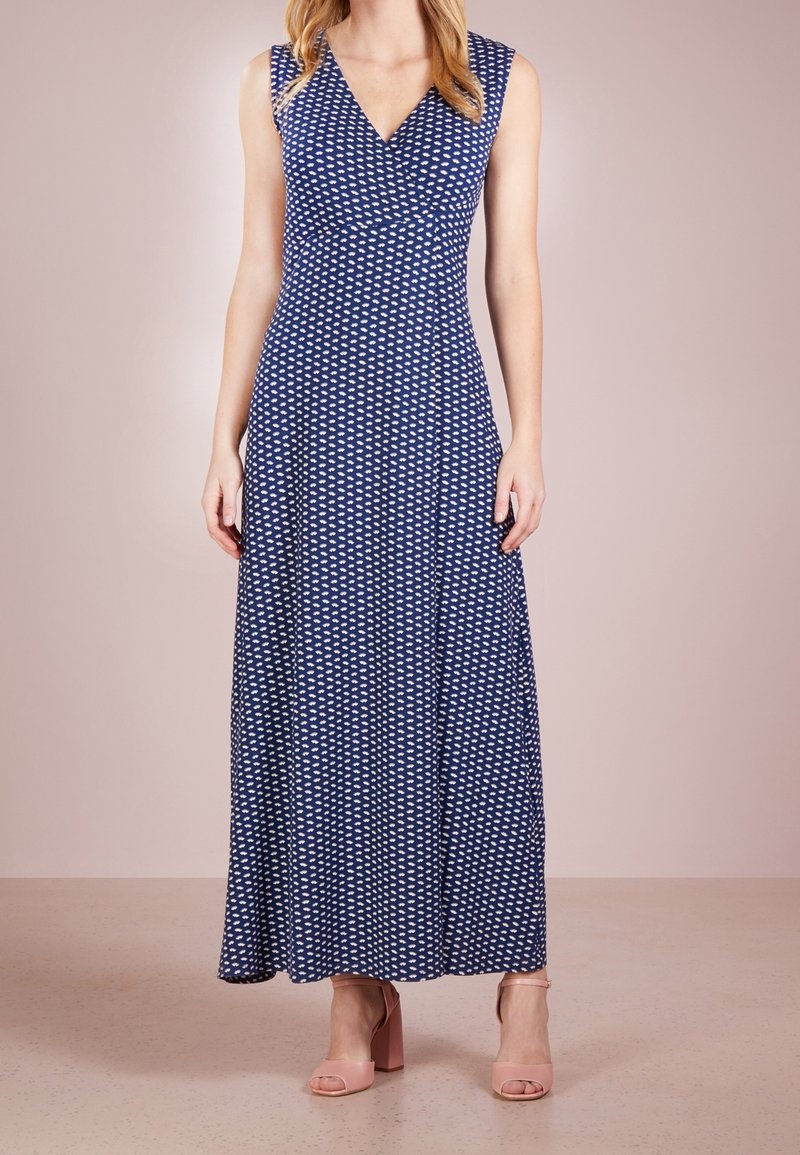 Robe maxi bleu marine avec un décolleté en V, sans manches et motif coeurs blancs. Tissu doux et extensible avec une silhouette fluide.