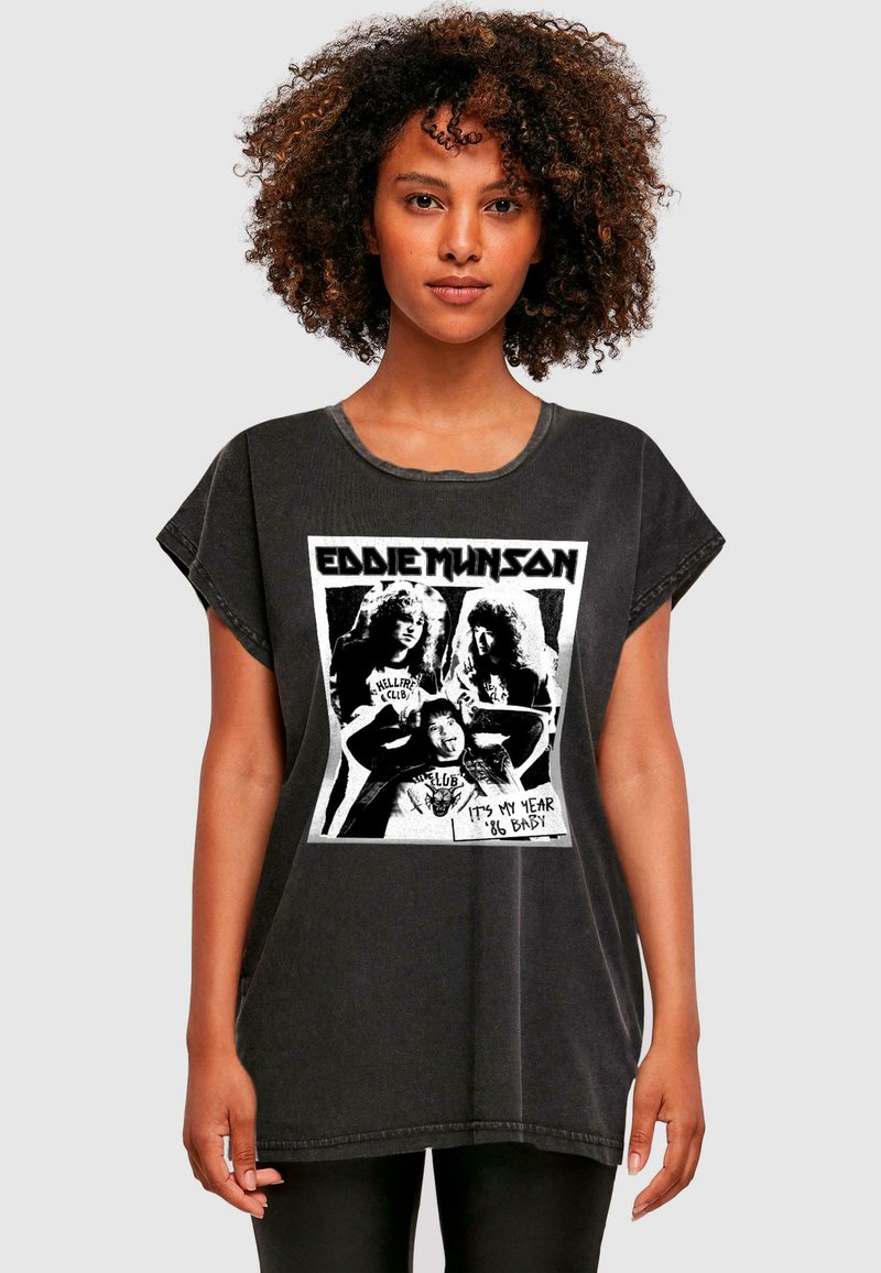 Čierne oversized tričko s grafickým potlačou s postavou Eddieho Munsona a textom. Bavlnená látka s distressed povrchom a vyhrnutými rukávmi.
