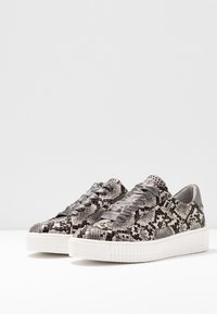 Gray and black snake-print sneakers with textured upper, satin laces, and white ridged sole. Sleek design with rounded toe and breathable material.