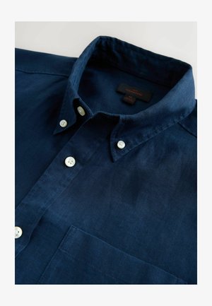 Marineblaues Leinenhemd mit einem Button-Down-Kragen, zwei weißen Knöpfen vorne und einer Brusttasche. Etikett ist innen am Kragen sichtbar.