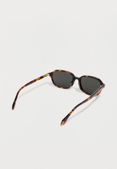 Ορθογώνια γυαλιά ηλίου με πλαίσιο σε απόχρωση χελώνας, με σκοτεινούς φακούς και λεπτούς, καμπυλωτούς βραχίονες, ανοιχτά τοποθετημένα πάνω σε λευκή επιφάνεια.