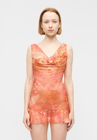 Φόρεμα χωρίς μανίκια με λαιμόκοψη τύπου κασκόλ, σε διάφανο πορτοκαλί ύφασμα με λουλουδάτα σχέδια δαντέλας και βολάν στο τελείωμα. Ομαλή υφή και εφαρμοστή σιλουέτα.