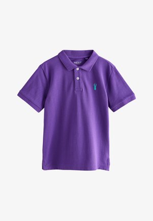 Fioletowa koszulka polo z krótkim rękawem, kołnierzykiem, dwoma białymi guzikami i małym turkusowym logo jelonka na lewej piersi.