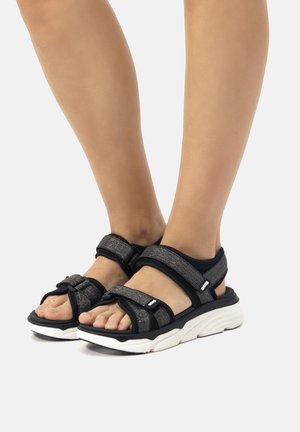 Sandali neri con due cinturini regolabili in velcro e parte superiore testurizzata. Presentano una suola bianca ammortizzata per supporto e comfort.