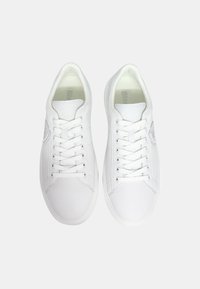 Sneakers bianchi in pelle con punta rotonda, lacci piatti e dettagli del logo in rilievo discreti sul lato. Texture liscia con design minimalista.