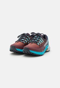 Paire de chaussures de trail Merrell bordeaux et turquoise avec des lacets noirs à motifs sur fond blanc.