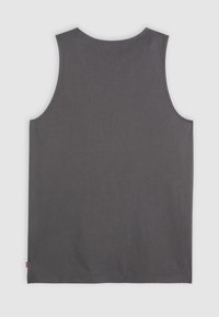T-shirt sans manches gris en coton. Il présente un col rond, un ourlet droit et une petite étiquette de logo en bas à gauche.