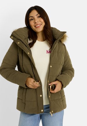 Veste matelassée vert olive avec capuche bordée de fourrure, détails en métal doré, fermetures éclair et à pression, et une poche poitrine unique.