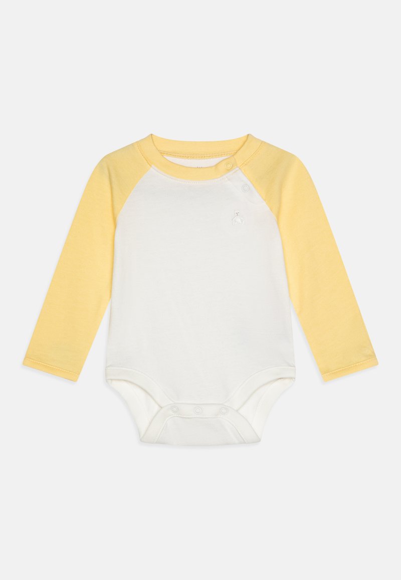 Langermet bodystocking med hvit kropp og gule raglan-ermer, laget av myk bomull med trykknapper på bena for enkel skifting.
