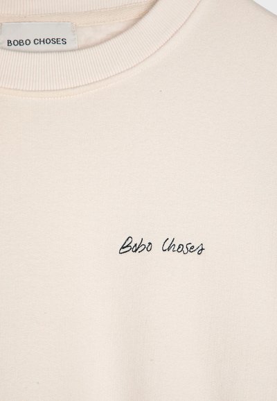 Felpa beige con collo a giro e polsini a coste. Testo ricamato "Bobo Choses" in filo scuro sul davanti. Tessuto morbido.