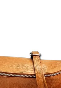 Leren schoudertas in tan kleur met een gestructureerde afwerking, een opvallende rits en een stevige verstelbare schouderband. Eenvoudig ontwerp, geen extra versieringen.