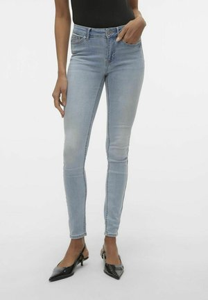 Lichtblauwe skinny jeans van denim, met een klassiek vijf-pocketontwerp en subtiele vervaging, gecombineerd met zwarte puntige hakken.