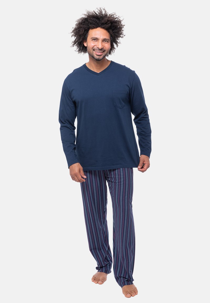 Maglietta a maniche lunghe blu marino con scollo a V e tasca, abbinata a pantaloni da pigiama a righe blu, rossi e bianchi. Tessuto di cotone morbido, vestibilità comoda.