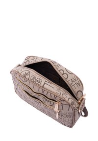 Borsa a mano rettangolare in tessuto beige con motivo logo. Presenta zip in tono oro e una finitura texture. La parte superiore aperta rivela un interno nero.